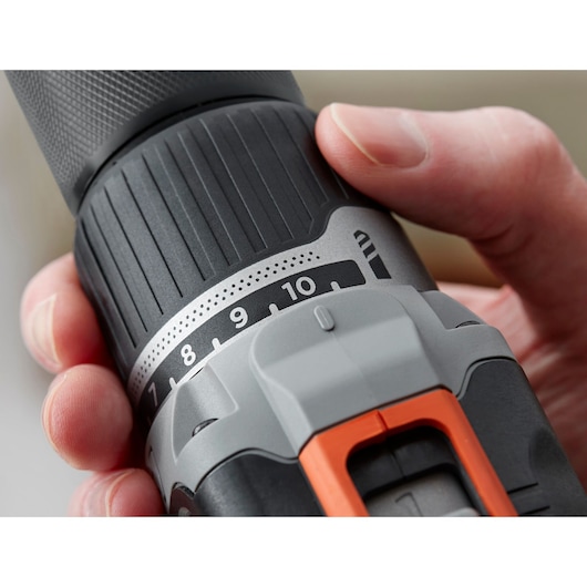 Close-up photo of BLACKDECKER cordless drill BCD003MEM2K grip and torque setting dial, hand adjusting controls.