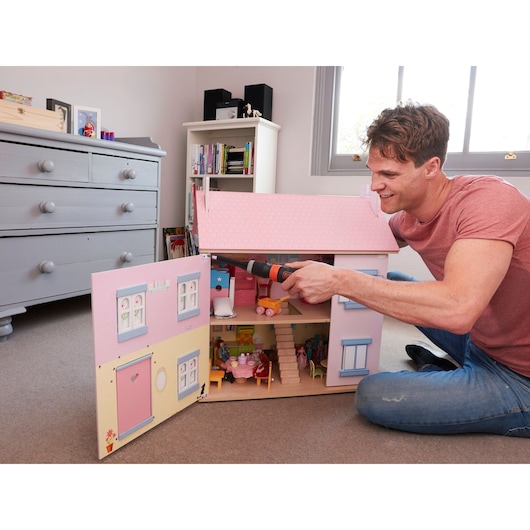 BLACKDECKER BCF601C cordless screwdriver used to assemble a pink wooden dollhouse indoors.