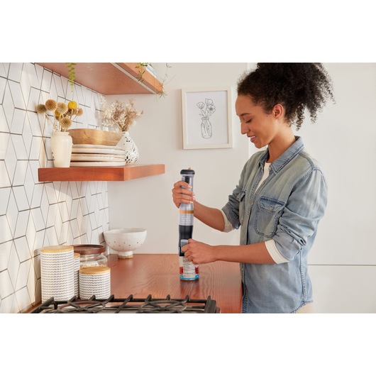BLACKDECKER BCKM1012KG handheld mixer in use on kitchen counter, modern decor in background.