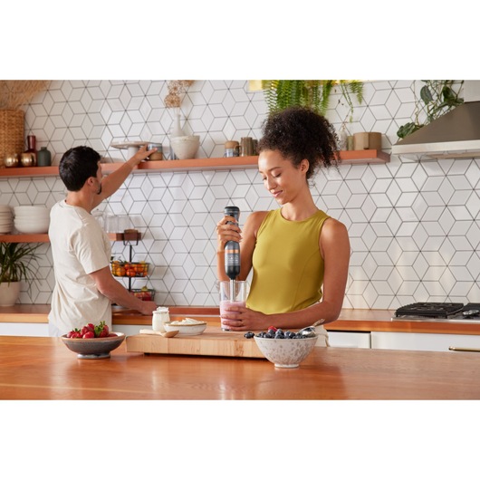 BLACKDECKER BCKM1012KG hand blender used to mix smoothie in a glass in a modern kitchen setting.