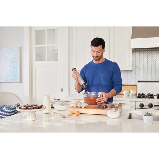 BLACKDECKER BCKM1012KG hand mixer used to mix batter in a glass bowl in a modern kitchen setting.