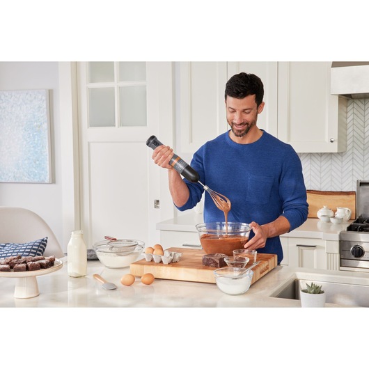 BLACKDECKER BCKM1012KG hand mixer used in a kitchen for mixing batter in a glass bowl.