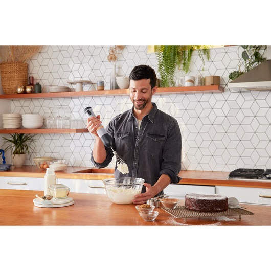 BLACKDECKER BCKM1012KG hand mixer used to whip ingredients in glass bowl on kitchen counter.