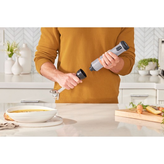 BLACKDECKER BCKM1016KSG hand blender in kitchen, person assembling silver and black appliance.