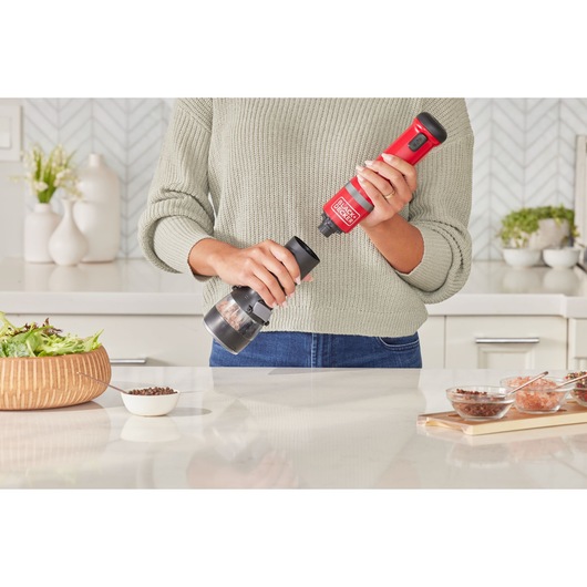 Photo of BLACKDECKER electric spice grinder BCKM101SPFF held in kitchen, red and black design.
