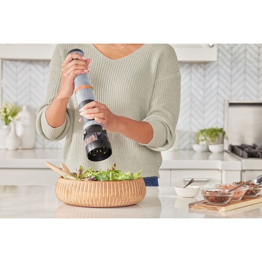 Photo of BLACKDECKER BCKM101SPFF electric pepper mill used above a salad bowl in a modern kitchen.