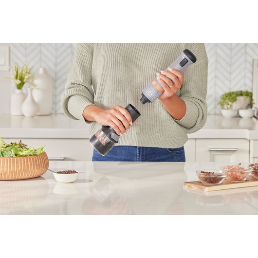 Photo of BLACK+DECKER BCKM101SPFF cordless spice grinder in use over a kitchen counter.
