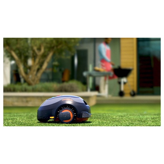 BLACKDECKER BCRMW122 robotic lawn mower on grass, outdoor setting with blurred background.