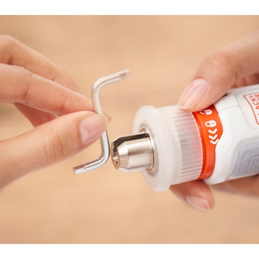 BLACKDECKER BCRTA01 rotary tool with metal hex key held near the chuck, close-up photography.