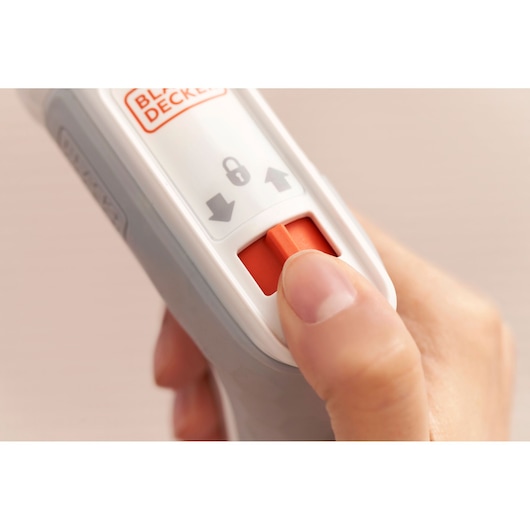 BLACKDECKER BCRTA01 remote control close-up showing orange lock switch and hand pressing button.