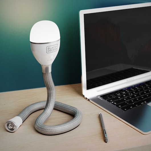 BLACK+DECKER BDCFSL01 flexible desk lamp with braided stand next to a laptop on a light wood surface.