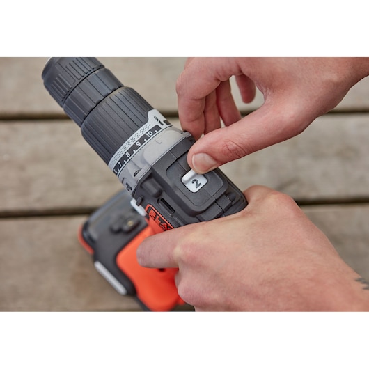 Close-up photo of BLACKDECKER BDCHD12S1 cordless drill being adjusted by hand, focus on gear selector.