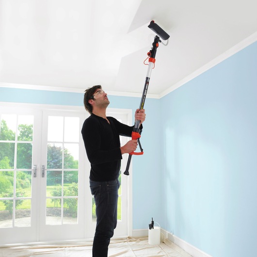 BLACKDECKER BDPR400 paint roller with extension pole used on ceiling in bright room.