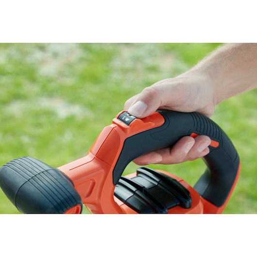 BLACKDECKER BEBLV300 leaf blower handle close-up showing control switch in use.