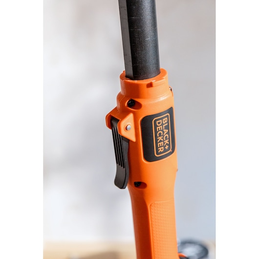 Close-up of an orange BLACK+DECKER handle with trigger, featuring black branding and textured grip.