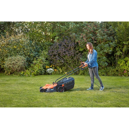 BLACKDECKER BEMW471BH electric lawn mower in use outdoors, orange and black design, product category: Photography