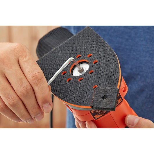 BLACKDECKER BEW200 sander closeup showing pad attachment with hex key, held in hand.