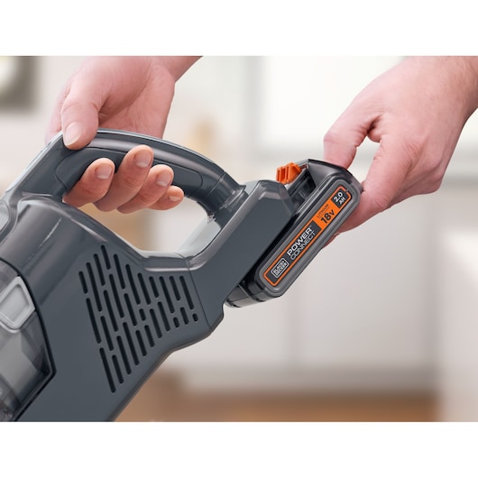 BLACKDECKER BHFEA18D1 handheld vacuum cleaner battery being inserted, close-up view.