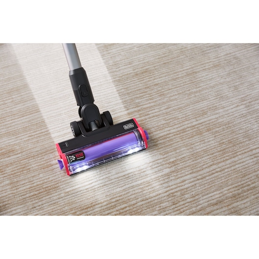 BLACKDECKER BHFEA640WP cordless stick vacuum cleaner head with LED lights cleaning beige carpet, top angle.