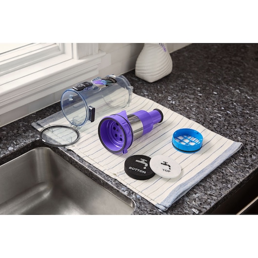 BLACKDECKER BHFEA640WP vacuum filter components and dustbin on kitchen counter, parts laid on striped towel.