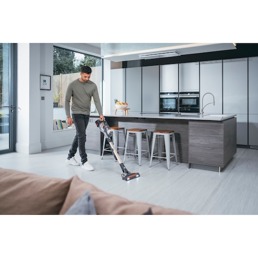 BLACKDECKER BHFEV36B2D cordless stick vacuum in use on modern kitchen floor.