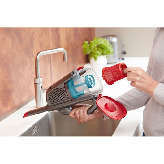 BLACKDECKER BHHV315J handheld vacuum showing filter removal over kitchen sink.