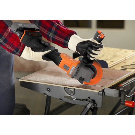 Photo of BLACKDECKER BLCG78M1 cordless angle grinder in use cutting a tile on a workbench.