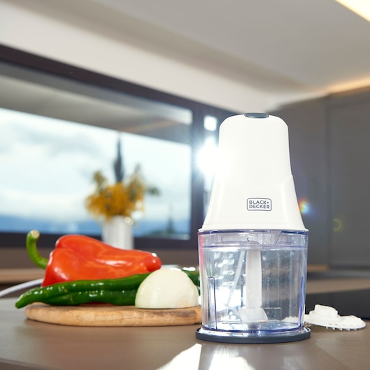 BLACK+DECKER BXCH260E food chopper on a kitchen counter with vegetables in the background.