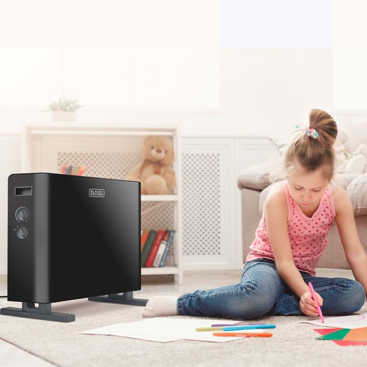 BLACKDECKER BXCSH2000E black convection heater in home setting near child drawing on carpet.