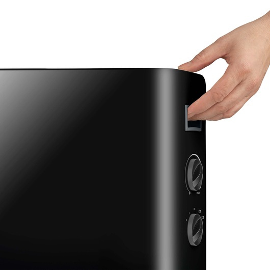 BLACKDECKER BXCSH2000E black heater with side control knobs, close-up of hand pressing button, front angle.