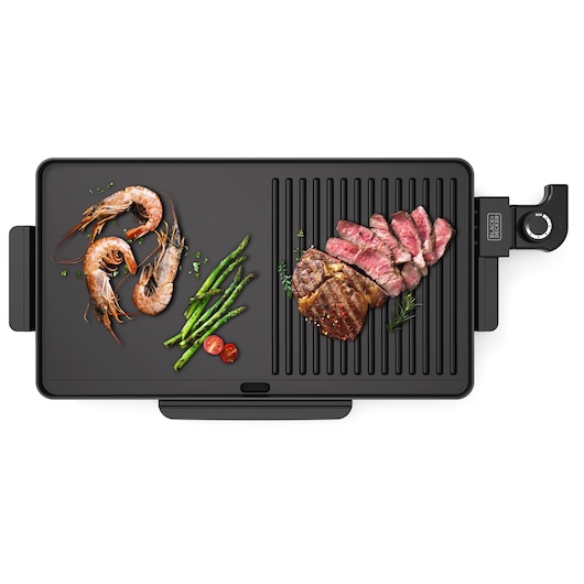 Top view of a BLACK+DECKER electric grill with food items including shrimp, asparagus, cherry tomatoes, and sliced steak placed on the grill surface.