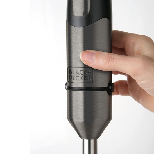 Photo of a hand holding a BLACK+DECKER BXHB1000E stainless steel hand blender close-up.