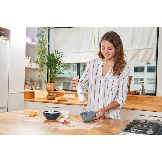 BLACKDECKER BXHBA600E hand blender used for mixing ingredients in a kitchen setting.