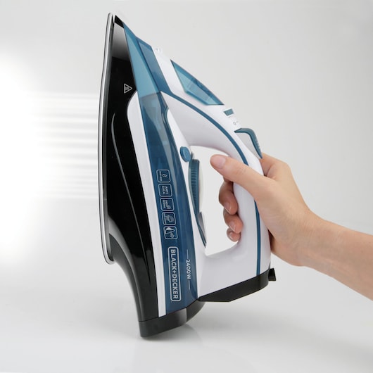 Photo of BLACK+DECKER BXIR2400E steam iron, white and blue, side angle, held by hand.
