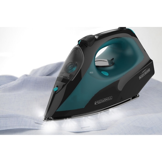 Photo of BLACK+DECKER BXIR2403E steam iron in black and teal, side angle, ironing a blue shirt.