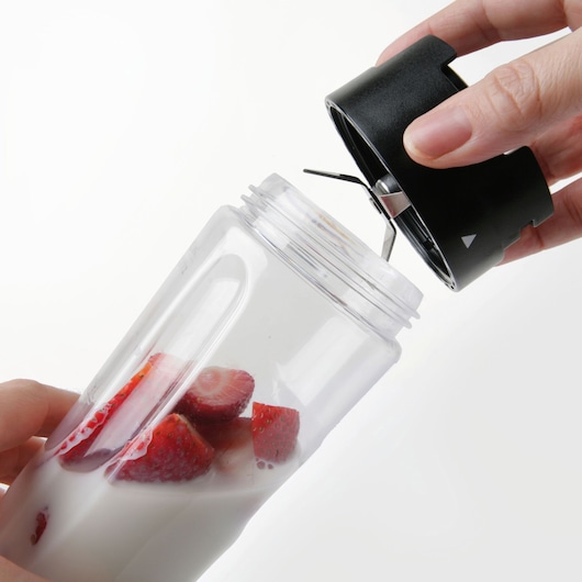 BLACKDECKER BXJBA350E blender bottle with blade lid, containing milk and strawberries, side angle
