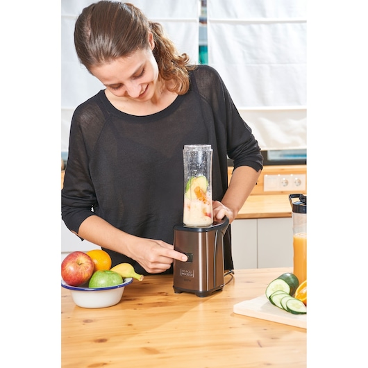 BLACKDECKER BXJBA350E blender with fruits on kitchen table, woman operating appliance.