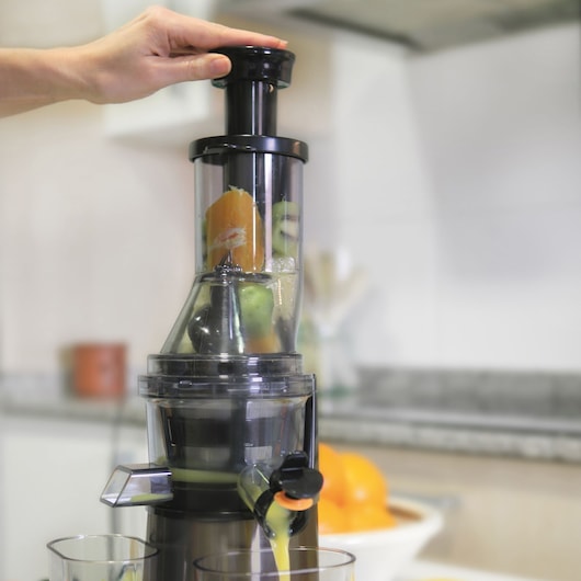 BLACKDECKER BXJE200E juicer extracting juice from fruits in a kitchen setting, front angle.