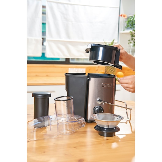 BLACKDECKER BXJE600E juicer with parts disassembled, placed on kitchen table, side angle.