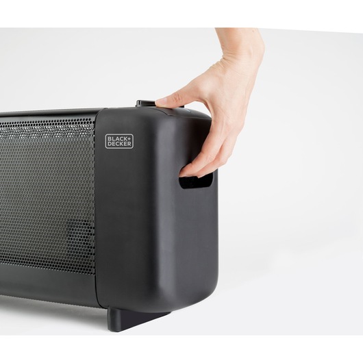 Photo of BLACK+DECKER BXMRA1500E heater, close-up view of black side handle with hand holding it.