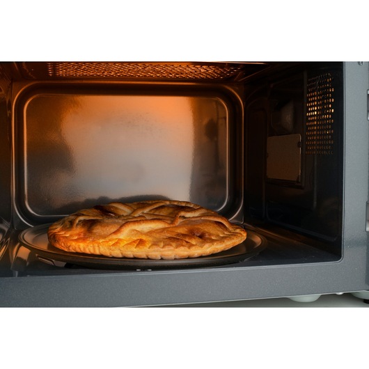BLACKDECKER BXMZ900E microwave oven interior with a golden pie on the turntable, side angle.