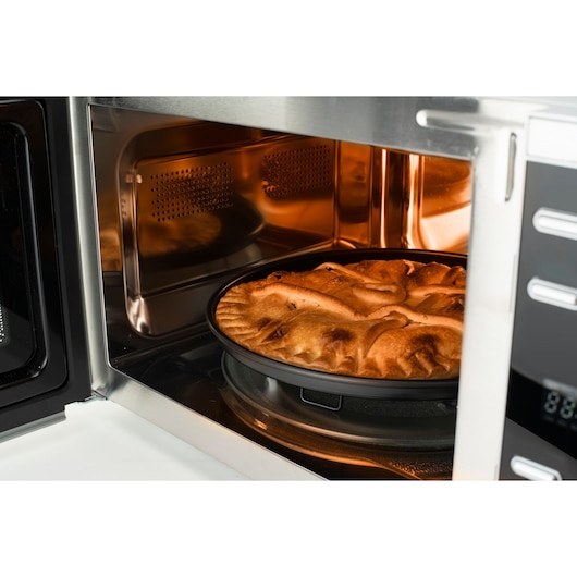 BLACKDECKER BXMZ901E microwave oven side view with a baked pie inside, stainless steel interior.