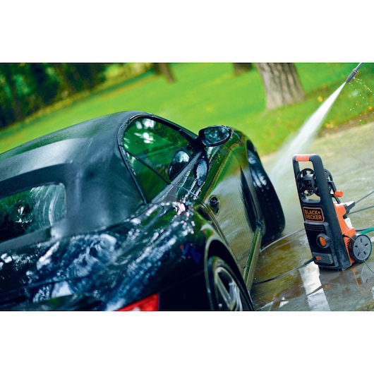 BLACKDECKER BXPW2100PE pressure washer cleaning a black convertible car outdoors.