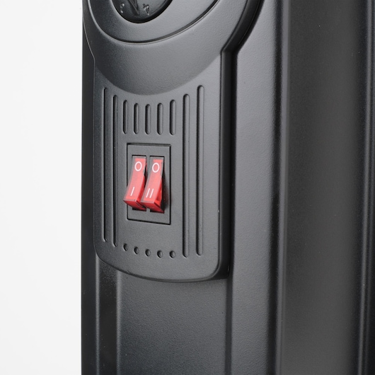 Photo of BLACKDECKER BXRA1500E heater close-up showing two red power switches on black panel, front angle.