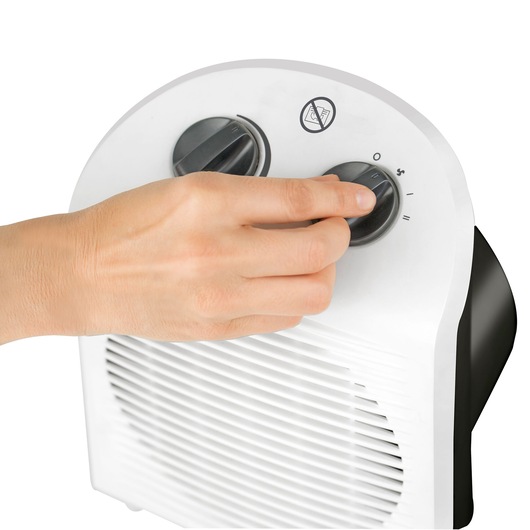 Photo of hand adjusting control knob on BLACKDECKER BXSH2000E white electric fan heater, close-up angle.