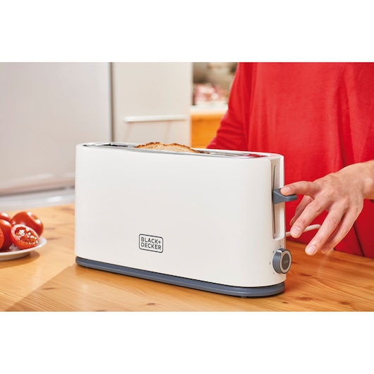 Photo of BLACKDECKER BXTO1001E toaster in use on kitchen table, side view.