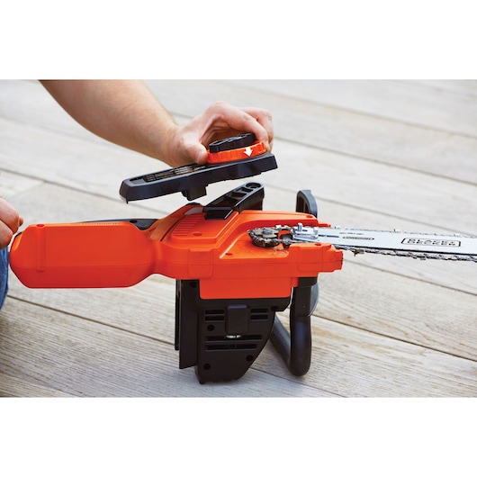 Photo of BLACKDECKER GKC1825L20 chainsaw with cover being removed, showing chain mechanism.