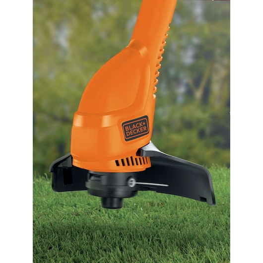 BLACKDECKER GL360 orange grass trimmer close-up on lawn, showing cutting head and protective guard.