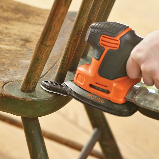 BLACKDECKER KA2000KA10 detail sander in use sanding an old wooden chair close-up.