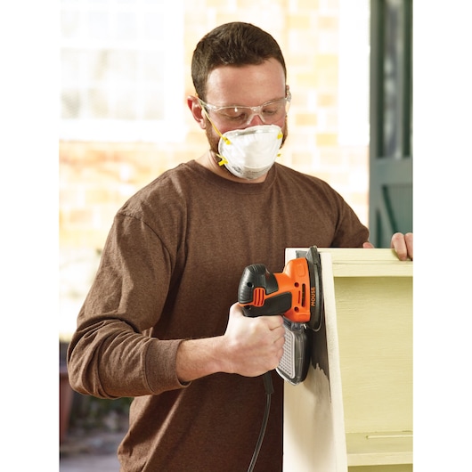 Photo of BLACKDECKER KA2000KA10 mouse sander in use on a wooden furniture piece.